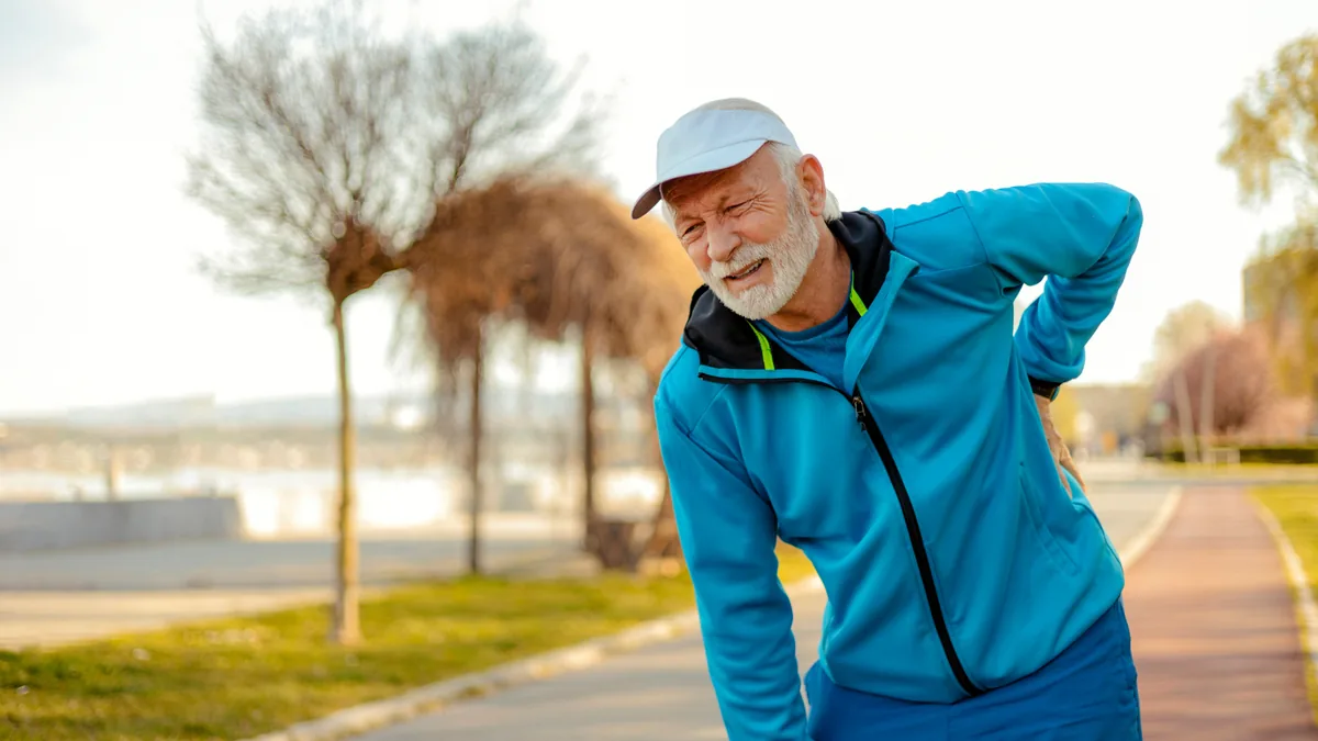 Älterer Mann beim Sport hält sich den Rücken