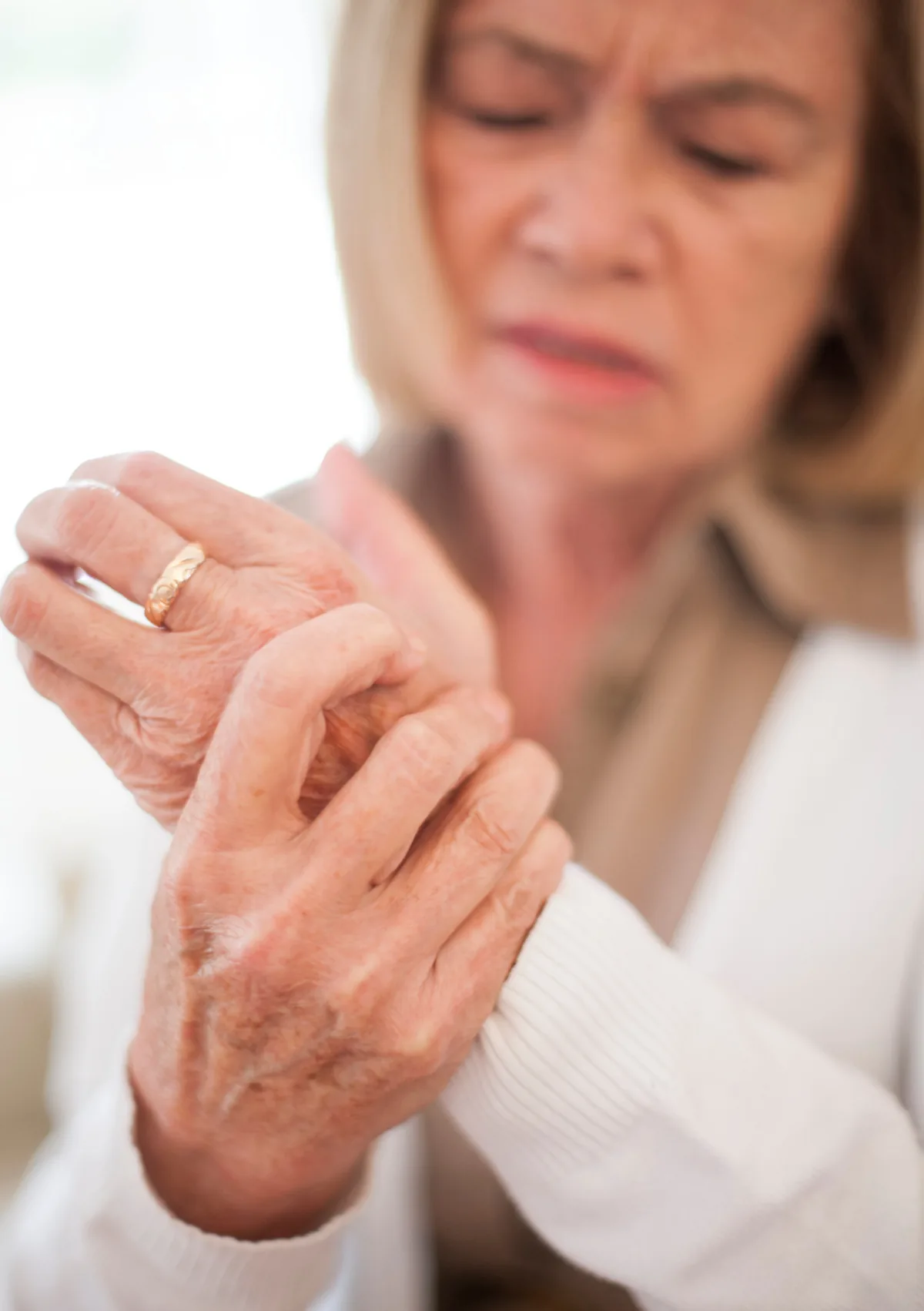 Ältere Frau massiert ihr Handgelenk