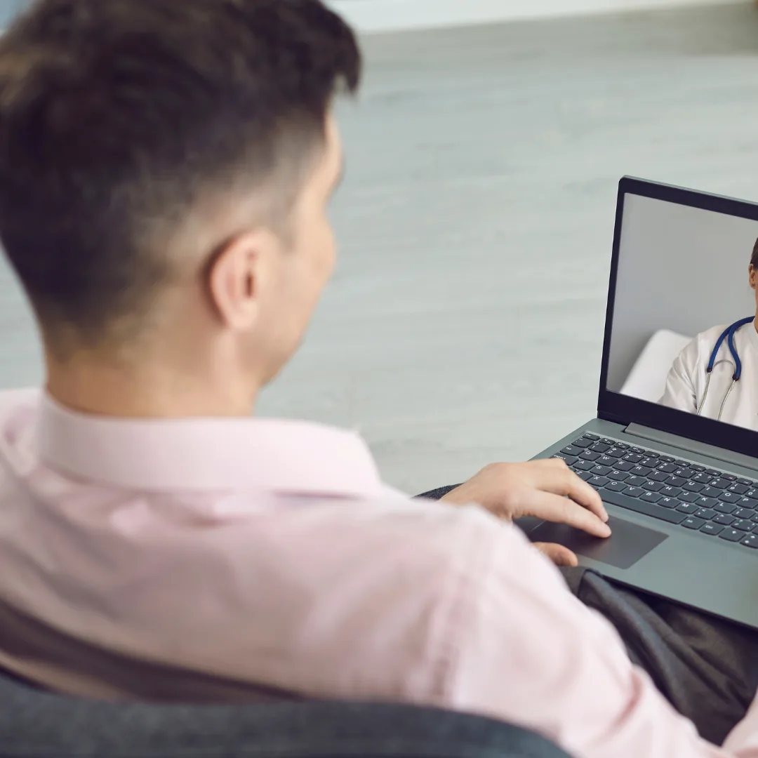 Mann in einer Videosprechstunde am Laptop