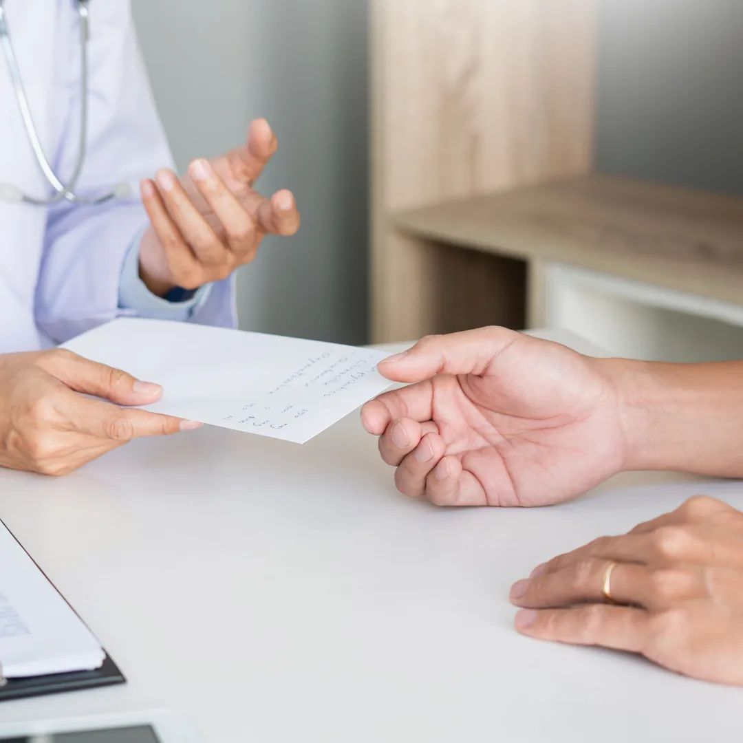 Arzt übergibt einem Patienten ein Dokument