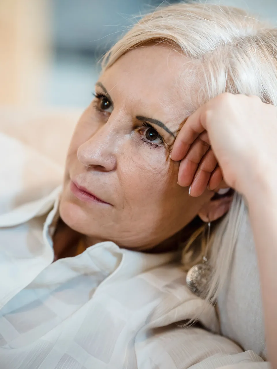 Frau Mitte fünfzig mit ruhigem Blick in weichem Licht
